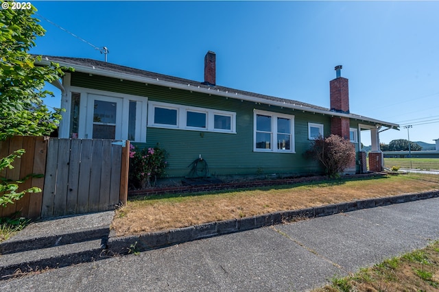 view of side of property featuring fence and a chimney