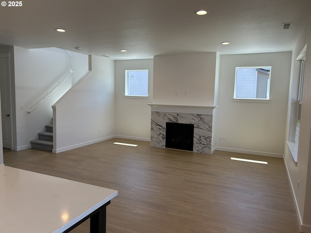 2940 Olympic St Unit 21, Woodburn, OR 97071 - unfurnished living room with wood finished floors, baseboards, stairway, a fireplace, and recessed lighting