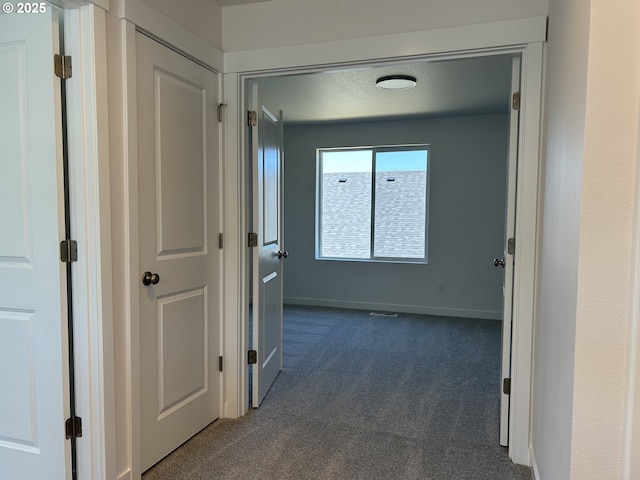 2940 Olympic St Unit 21, Woodburn, OR 97071 - hallway featuring dark carpet and baseboards