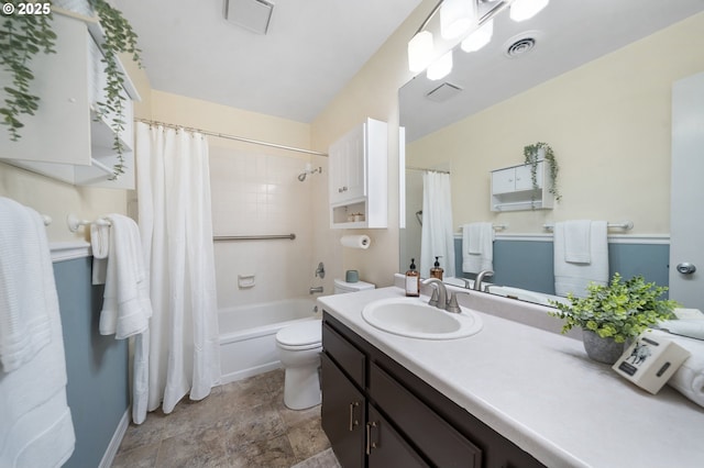 bathroom with vanity, toilet, shower / tub combo, and stone finish floors