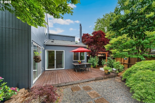 back of house with a wooden deck, outdoor dining area, and fence