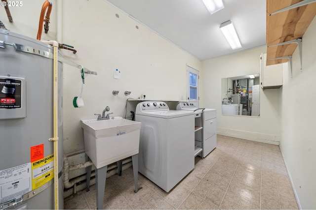 clothes washing area featuring water heater, separate washer and dryer, and light tile patterned floors