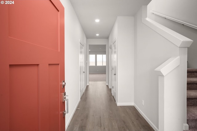 corridor with stairs, baseboards, wood finished floors, and recessed lighting