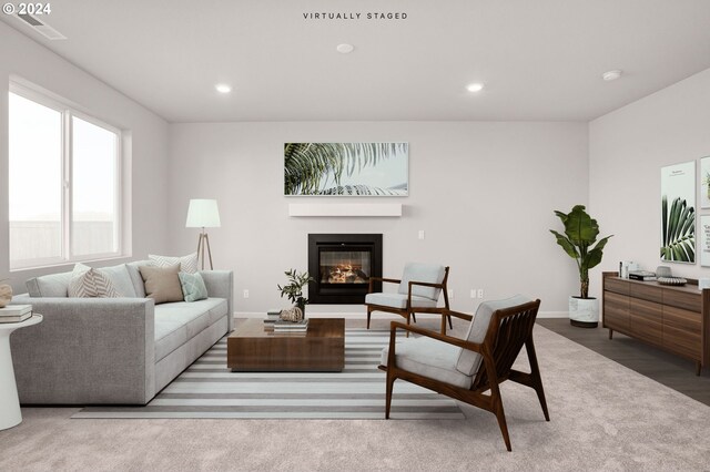 carpeted living room with recessed lighting, visible vents, baseboards, and a glass covered fireplace