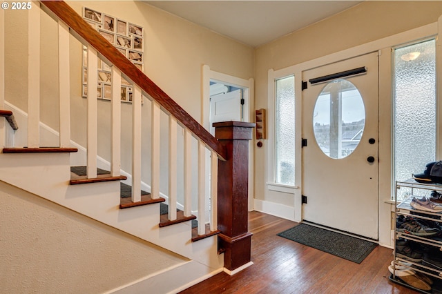 entryway with stairs, baseboards, and wood finished floors