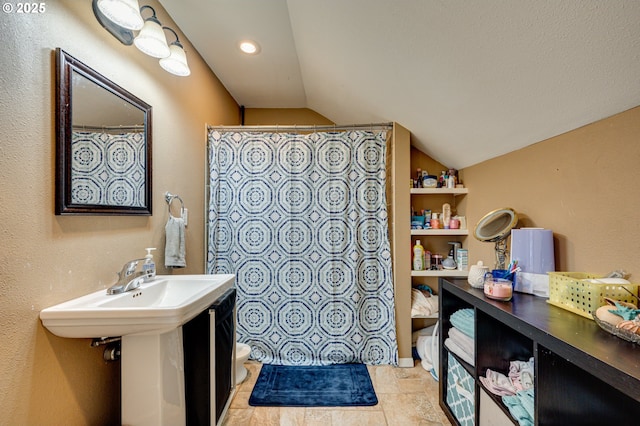 bathroom featuring toilet, a shower with curtain, and vaulted ceiling