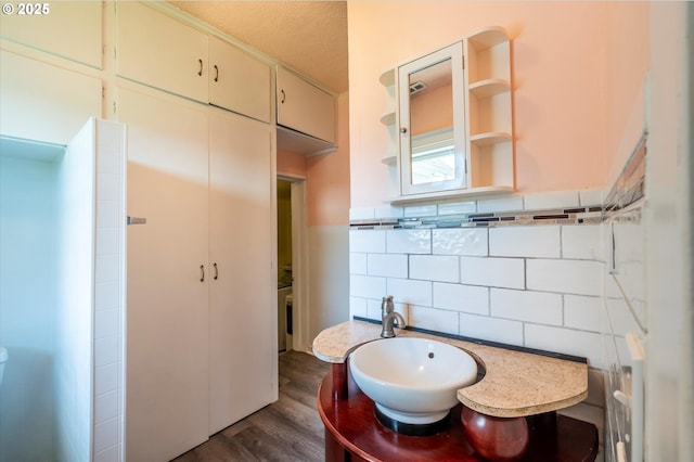 470 W 4th St, Coquille, OR 97423 - bathroom featuring wood finished floors, a textured ceiling, tile walls, vanity, and backsplash