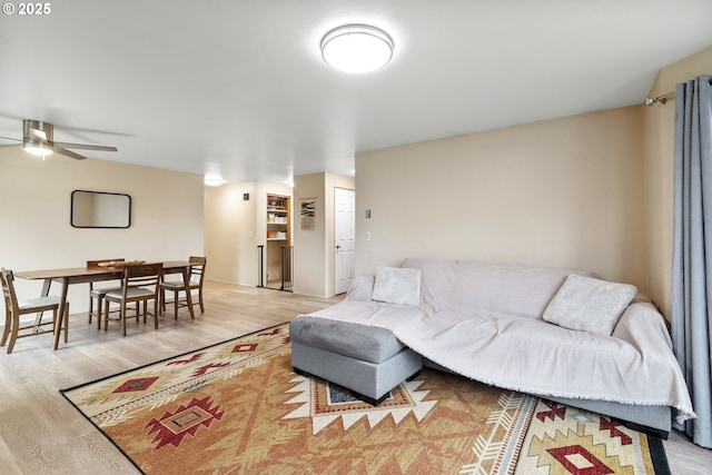 living room featuring light wood-type flooring and ceiling fan