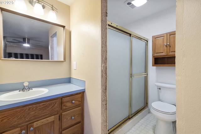 bathroom featuring vanity, a shower stall, toilet, and tile patterned floors