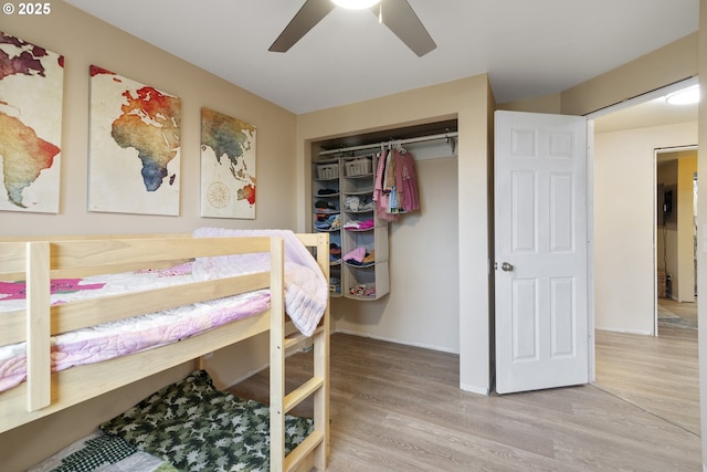 bedroom with a closet, ceiling fan, and light wood-style flooring