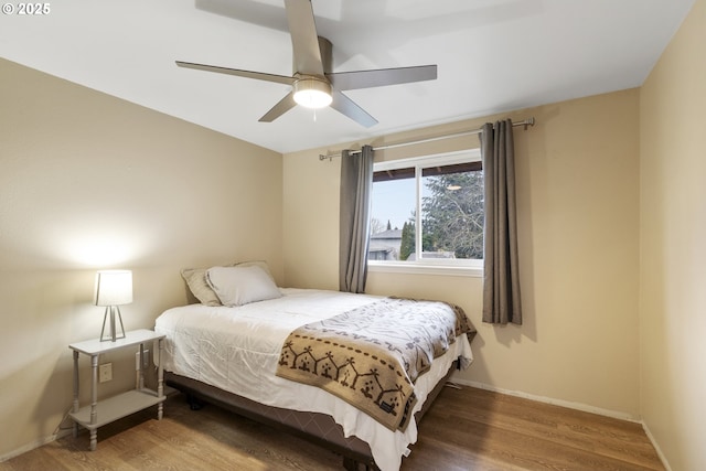 bedroom featuring a ceiling fan, baseboards, and wood finished floors