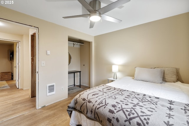 bedroom featuring a ceiling fan, a closet, visible vents, and light wood finished floors