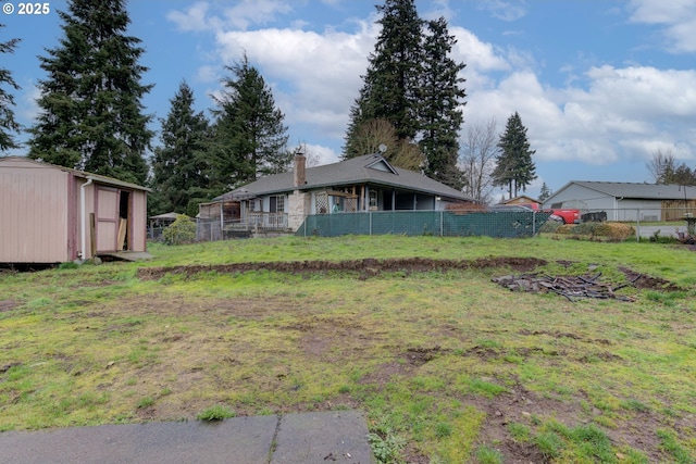 view of yard with a storage unit, fence, and an outdoor structure