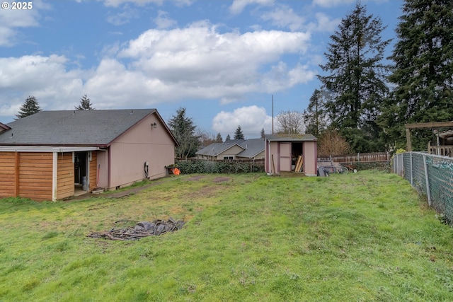 view of yard featuring an outbuilding, a storage unit, and a fenced backyard