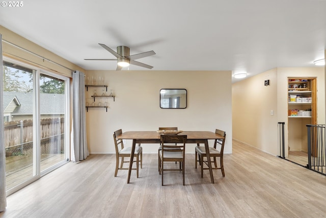 dining room featuring light wood finished floors, a ceiling fan, and baseboards