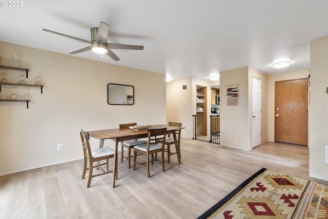 dining room featuring ceiling fan, light wood-style flooring, and baseboards