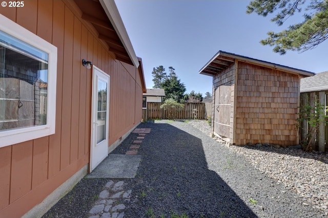 view of side of property featuring fence, crawl space, an outdoor structure, and a shed