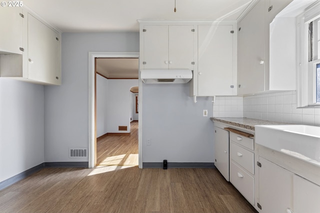 kitchen with under cabinet range hood, visible vents, white cabinets, and wood finished floors