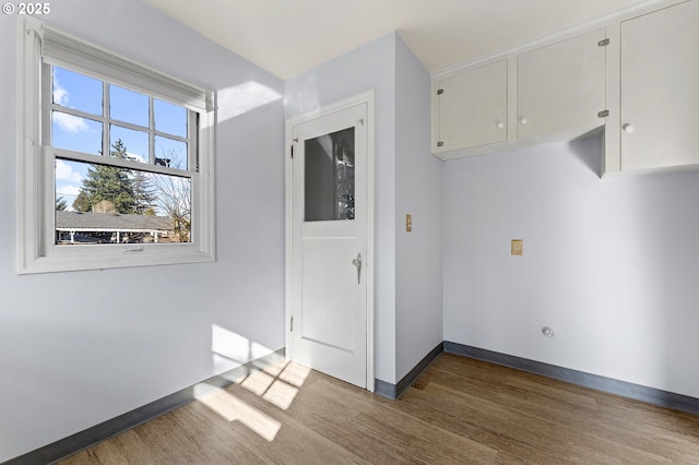 interior space with baseboards and wood finished floors