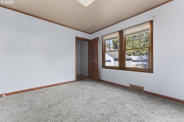 carpeted spare room with visible vents, crown molding, and baseboards