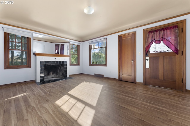 unfurnished living room featuring baseboards, a fireplace, visible vents, and wood finished floors