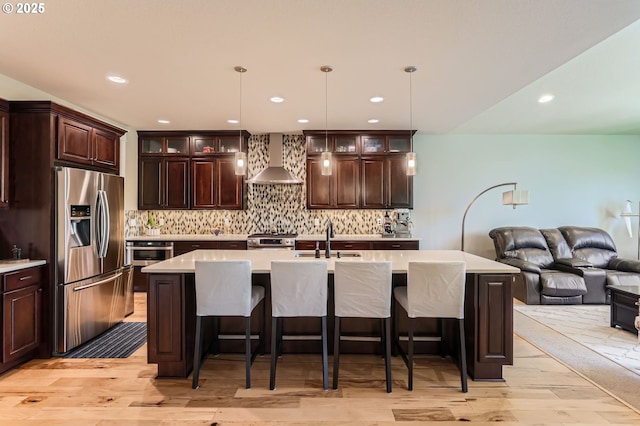 10183 NW Crossing Dr, Portland, OR 97229 - kitchen featuring appliances with stainless steel finishes, wall chimney range hood, a sink, open floor plan, and light wood-type flooring