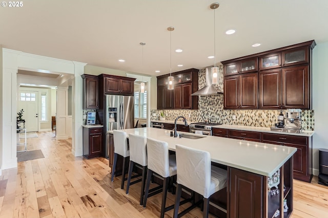 10183 NW Crossing Dr, Portland, OR 97229 - kitchen featuring a sink, wall chimney exhaust hood, appliances with stainless steel finishes, backsplash, and dark brown cabinetry