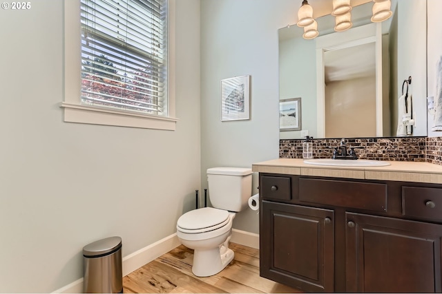 10183 NW Crossing Dr, Portland, OR 97229 - half bath with toilet, vanity, tasteful backsplash, wood finished floors, and baseboards