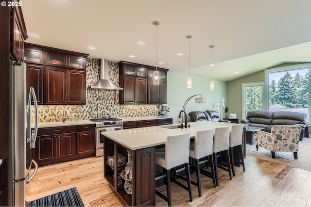 10183 NW Crossing Dr, Portland, OR 97229 - kitchen with appliances with stainless steel finishes, wall chimney range hood, open floor plan, light wood-style flooring, and lofted ceiling