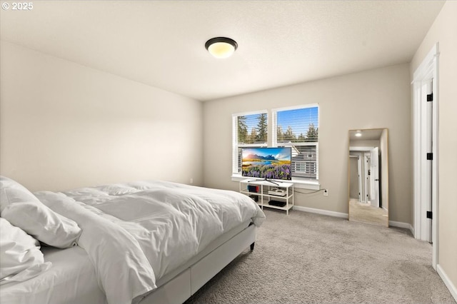 bedroom with light carpet and baseboards