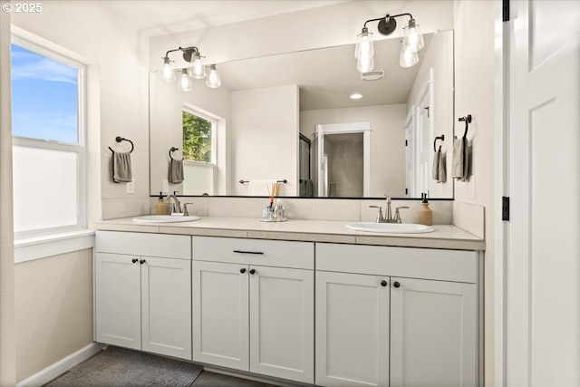 bathroom featuring a sink, baseboards, and double vanity