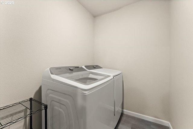 laundry room with laundry area, baseboards, washing machine and clothes dryer, and wood finished floors