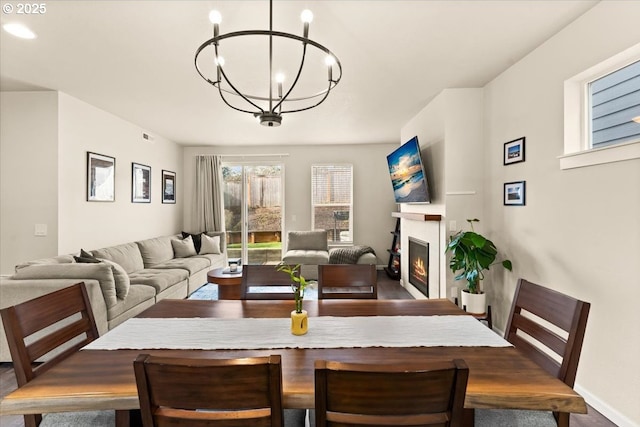 12977 SE Creekside Ter, Happy Valley, OR 97086 - dining space with a chandelier, a glass covered fireplace, and baseboards