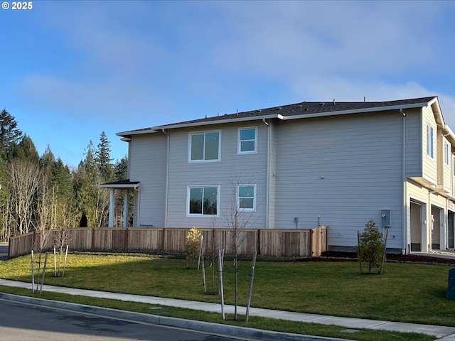 back of property featuring a yard and a garage