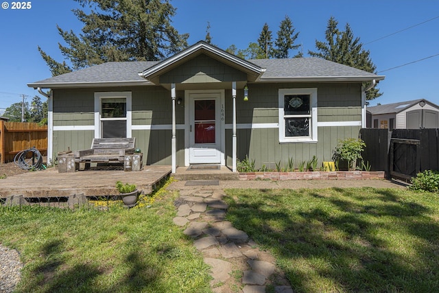 1646 E Gibbs Ave, Cottage Grove, OR 97424 - bungalow with fence, roof with shingles, a deck, and a front lawn