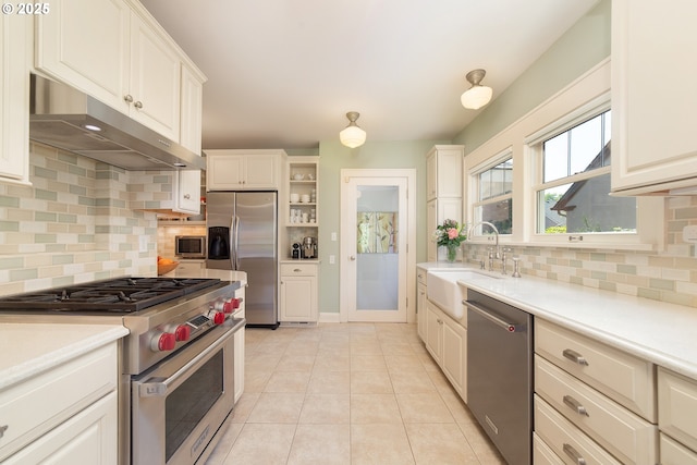 4052 NE 22nd Ave, Portland, OR 97212 - kitchen with stainless steel appliances, under cabinet range hood, light countertops, backsplash, and light tile patterned floors