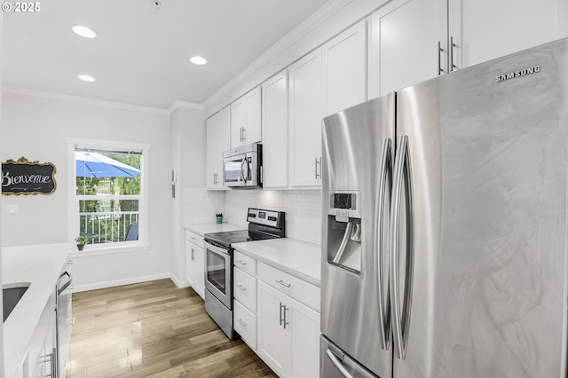 kitchen with wood finished floors, ornamental molding, stainless steel appliances, light countertops, and backsplash