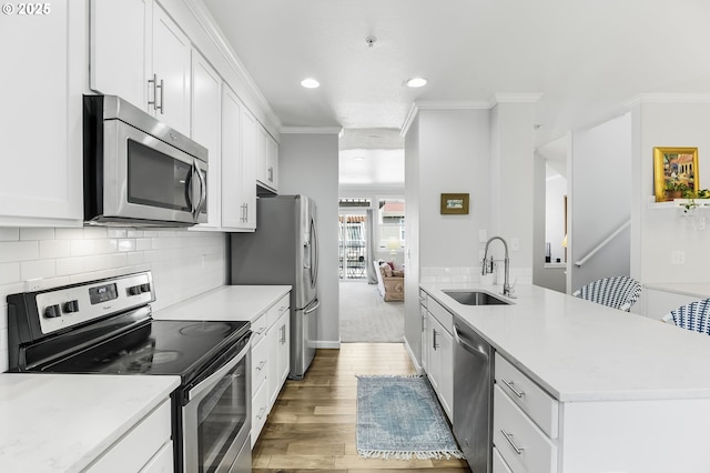 kitchen featuring a sink, decorative backsplash, ornamental molding, and stainless steel appliances