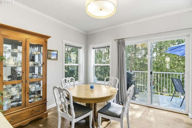 dining room featuring baseboards, wood finished floors, and crown molding