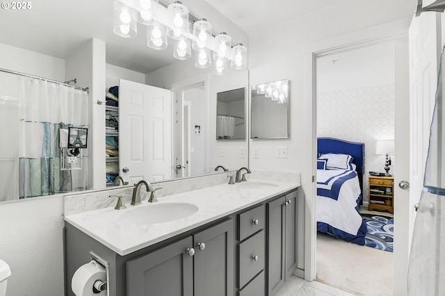 ensuite bathroom with double vanity, ensuite bath, and a sink