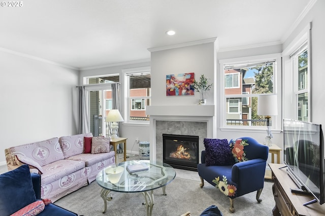 carpeted living area with crown molding, baseboards, and a premium fireplace