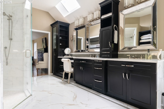 bathroom featuring a shower stall, marble finish floor, vaulted ceiling, and double vanity