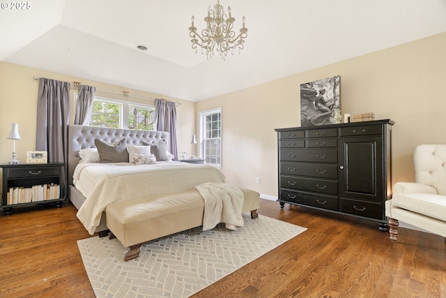 bedroom with a chandelier and wood finished floors