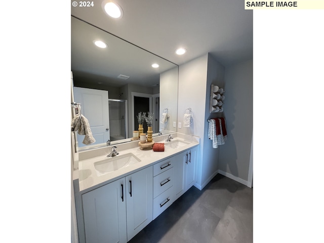 bathroom featuring double vanity, a shower with shower door, a sink, and recessed lighting