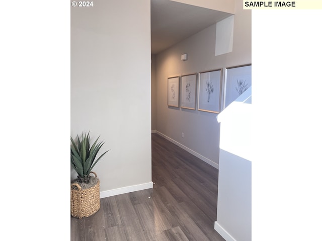 hallway with wood finished floors and baseboards