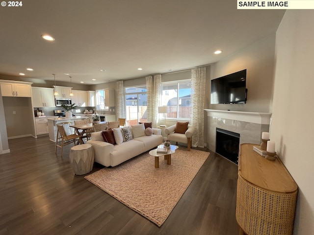 living area featuring dark wood-style floors, a fireplace, and recessed lighting