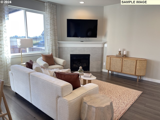 living area with recessed lighting, dark wood-style flooring, baseboards, and a tiled fireplace