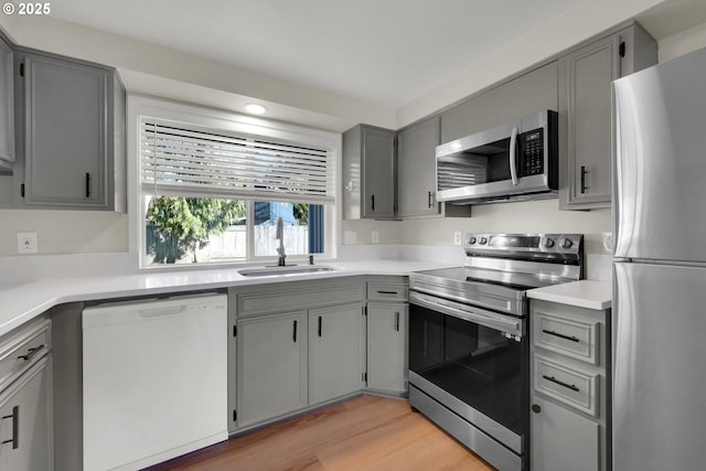 kitchen with appliances with stainless steel finishes, gray cabinets, and sink