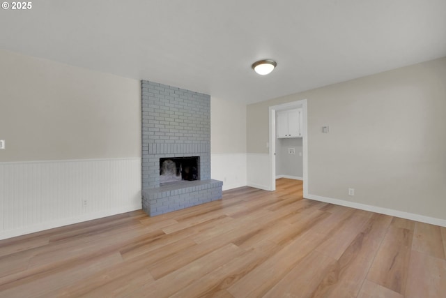 unfurnished living room featuring a fireplace and light hardwood / wood-style flooring