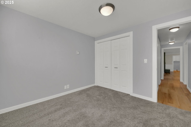 unfurnished bedroom with a closet and carpet flooring